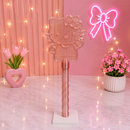 Pink Hello Kitty-themed brush with a neon bow light on a pink background