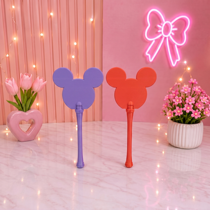 Two colorful fans with Mickey Mouse ears on a pink background with neon bow and flowers.